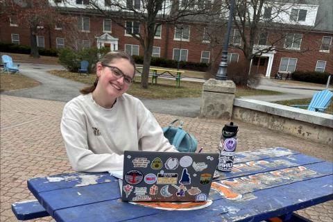 UNH student sitting at picnic table